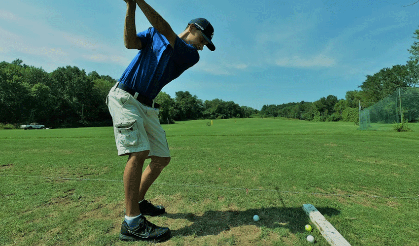 man in blue polo shirt playing golf